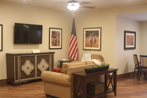 A cozy living room featuring an American flag and art on the walls.