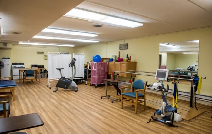 A rehabilitation room equipped with stationary bikes and other exercise equipment.