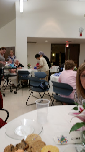 A community gathering taking place indoors with people engaged in various activities.
