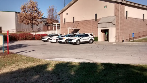 A row of police vehicles parked outside a law enforcement building.