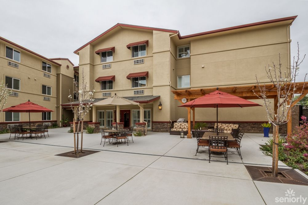 A residential building with outdoor patio seating and umbrellas.