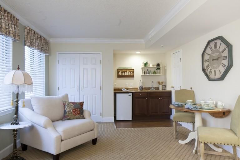 A cozy living room with a comfortable armchair and a mini-bar setup.