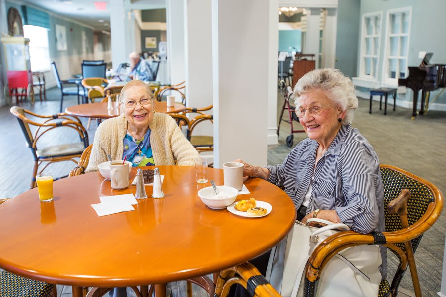 Two elderly women enjoying coffee and conversation at a caf.