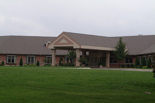 A modern building surrounded by a grassy area, featuring a welcoming entrance.