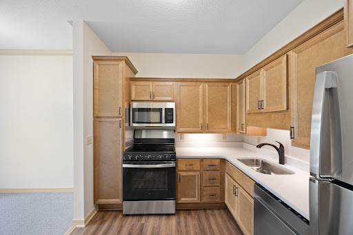 A modern kitchen featuring wooden cabinets and stainless steel appliances.