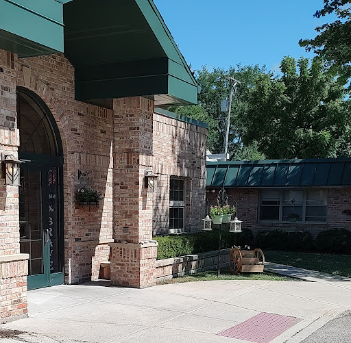 A well-designed brick building featuring a distinct entrance and surrounded by greenery.
