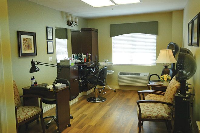 A cozy hair salon interior with a barber chair and mirror, surrounded by comfortable furniture.