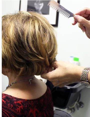 A woman receiving a haircut at a salon.