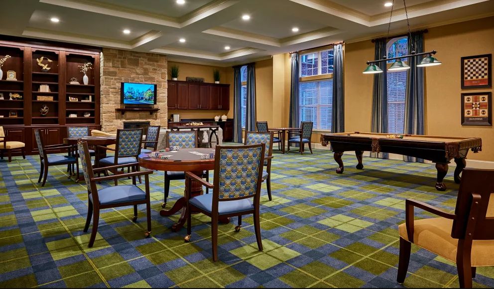 A well-furnished lounge area with a pool table and seating arrangements.
