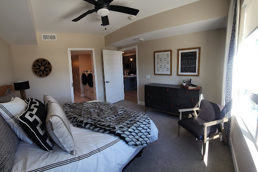 A cozy and modern bedroom featuring a neatly made bed, stylish furniture, and decorative artwork on the walls.