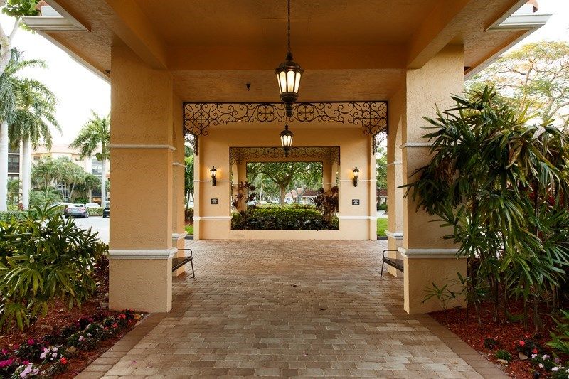 A covered entrance with hanging lanterns and potted plants on either side.