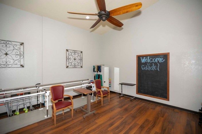 A well-lit physical therapy room with exercise equipment and a chalkboard.
