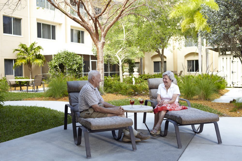 Two seniors enjoying a conversation in a garden setting.
