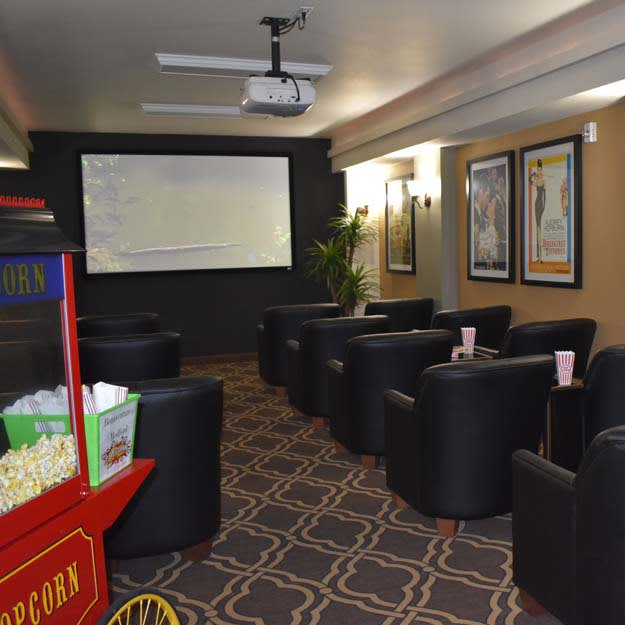 A cozy home theater setup with comfortable seating and a popcorn machine.