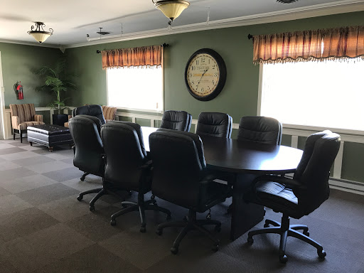 A spacious conference room equipped with a large table and comfortable seating, perfect for meetings.