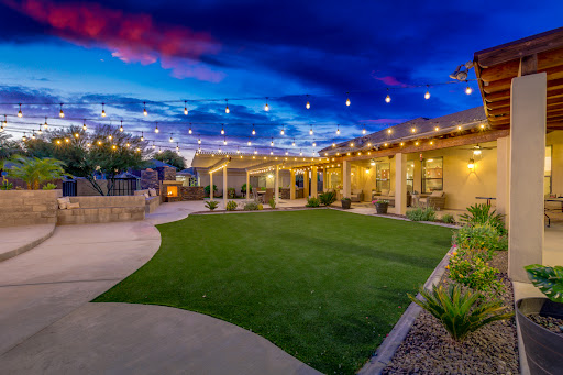 A tranquil outdoor space illuminated by string lights under a beautiful evening sky.