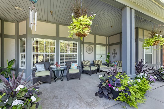 A cozy patio with comfortable seating and vibrant plants.