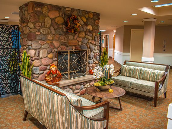 A cozy living room with a stone fireplace, modern seating, and stylish decor.