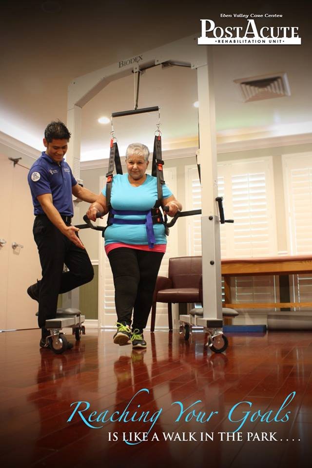 A healthcare professional assists an individual using physical therapy equipment for rehabilitation.