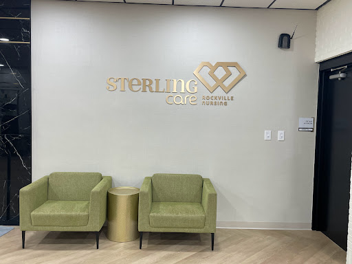 A modern waiting area featuring stylish green chairs and a branded wall in a healthcare setting.