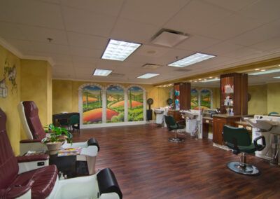 Interior of a salon with hair care stations, chairs, and decorative artwork on the walls.