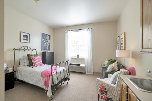 A bright and cozy bedroom featuring a vintage bed, soft pastel decor, and natural light streaming through the window.