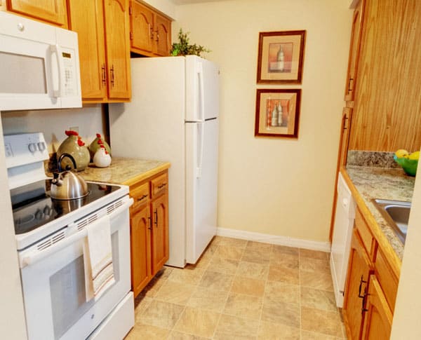 A cozy kitchen with wooden cabinetry, modern appliances, and decorative elements.