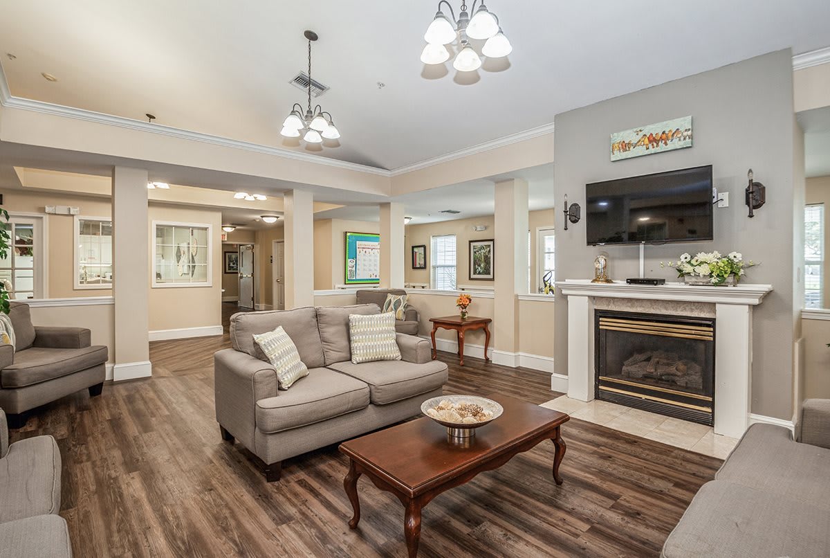 A cozy living room featuring a sofa, fireplace, and coffee table on a hardwood floor.