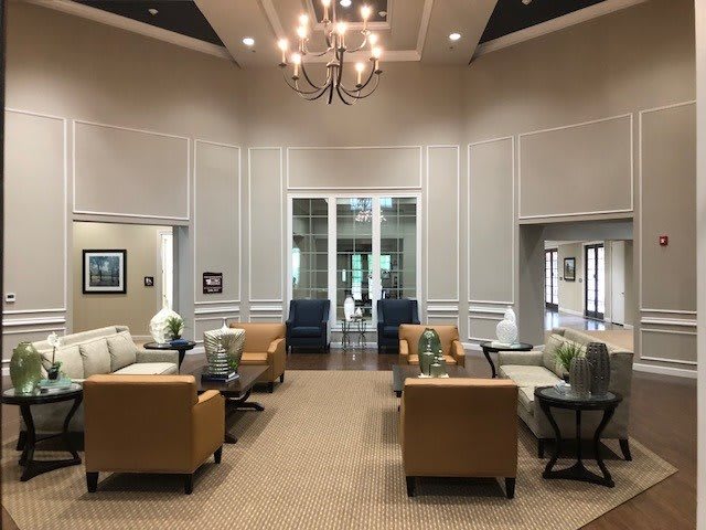 A spacious and elegant lobby with comfortable seating and a central chandelier.