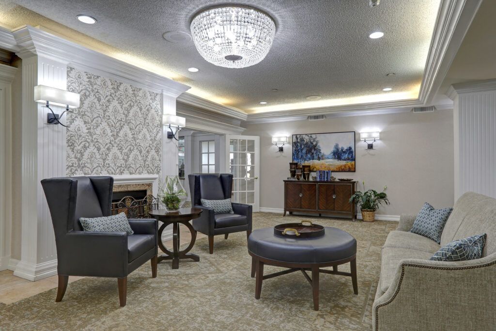 A cozy and elegantly decorated living room with comfortable seating, a stylish chandelier, and tasteful artwork.