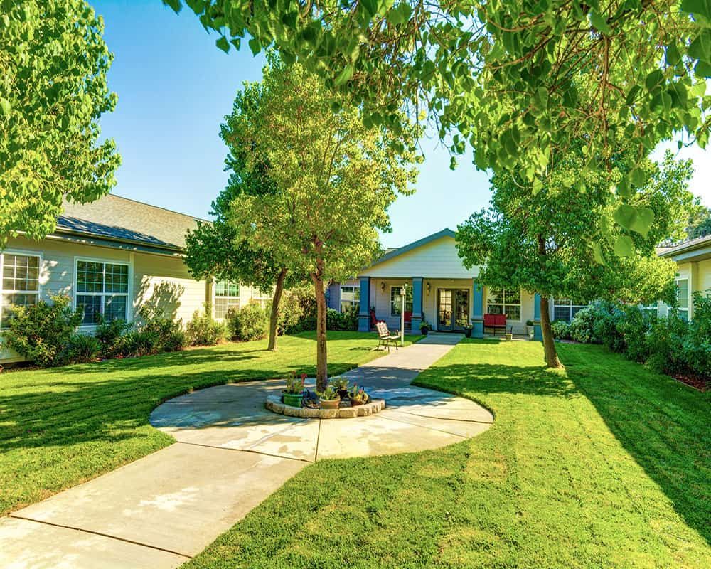 A charming house with a well-maintained garden and lush green surroundings.