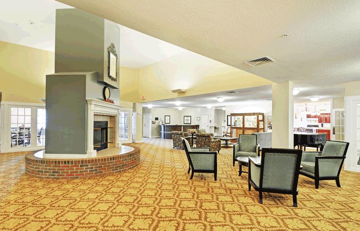 A spacious hotel lobby with a seating area and fireplace.