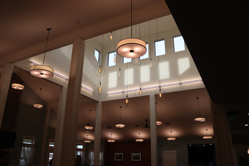 A view of the interior space featuring elegant lighting fixtures and large windows that illuminate the area.