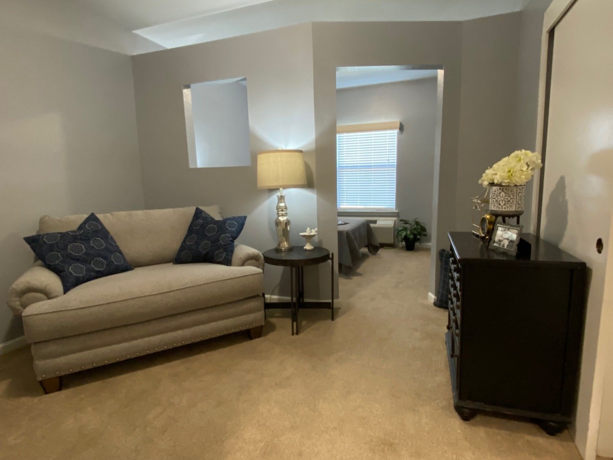 A cozy living room with a beige sofa, accent pillows, and a lamp creating a warm atmosphere.