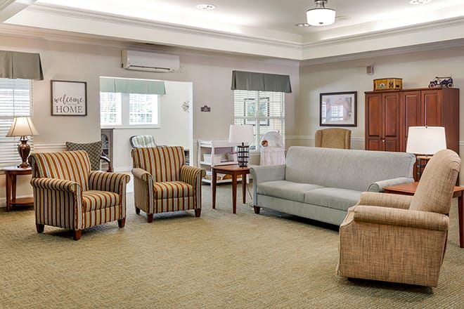 A cozy living room with sofas and chairs arranged around a small table.