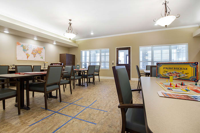 A spacious conference room with tables, chairs, and ample lighting.