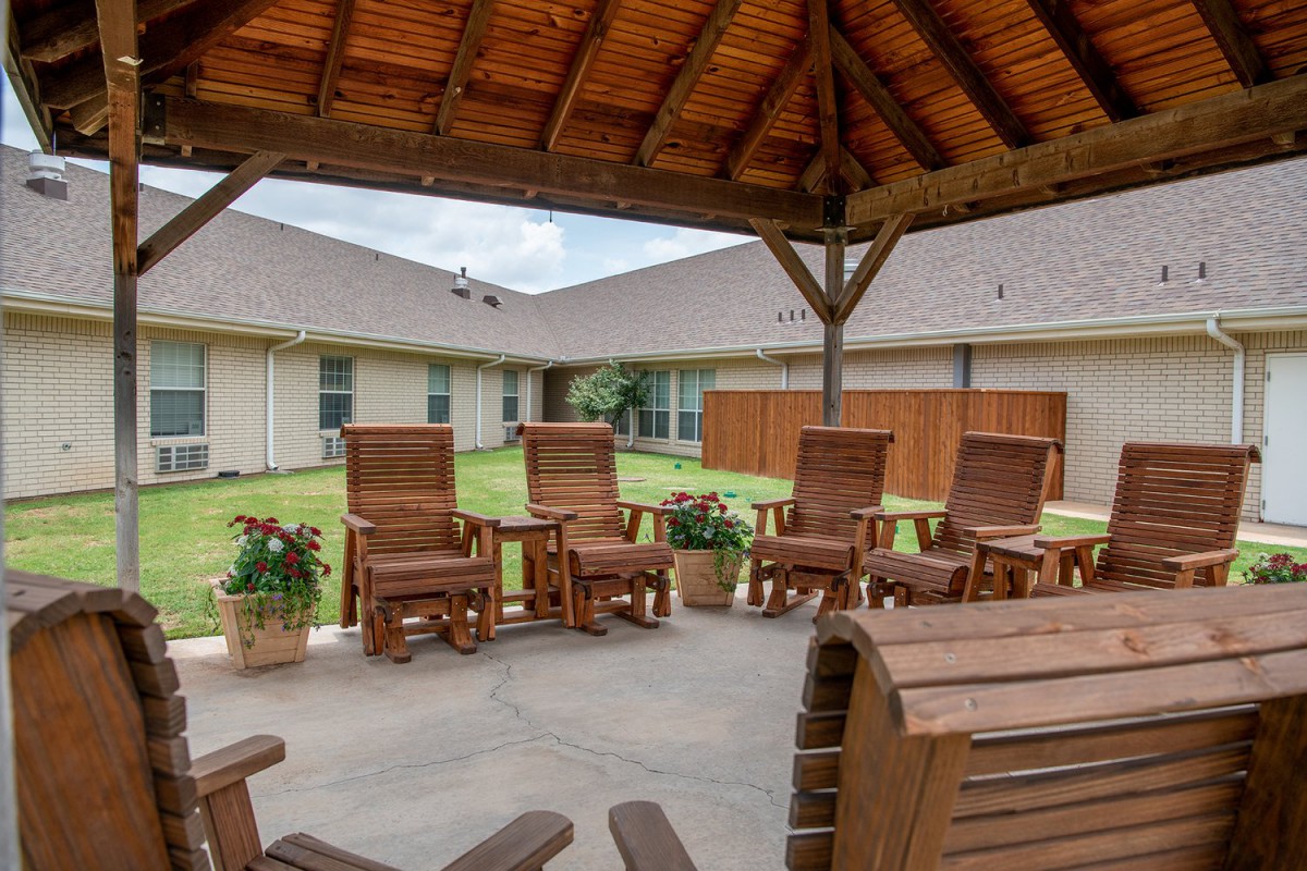 A cozy outdoor patio with wooden chairs under a gazebo, perfect for relaxation.