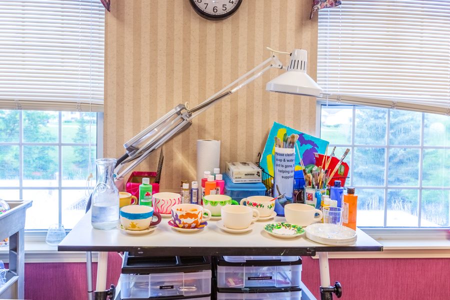 A well-organized art workspace with various supplies including paints, brushes, and crafting materials.