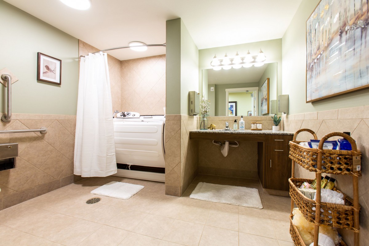 A modern bathroom with a walk-in shower, large mirror, and ample lighting.