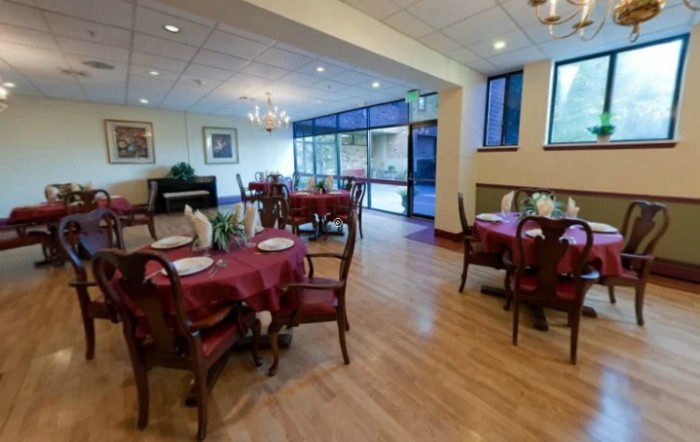 A cozy restaurant dining area with elegant tables and chairs, featuring ambient lighting.