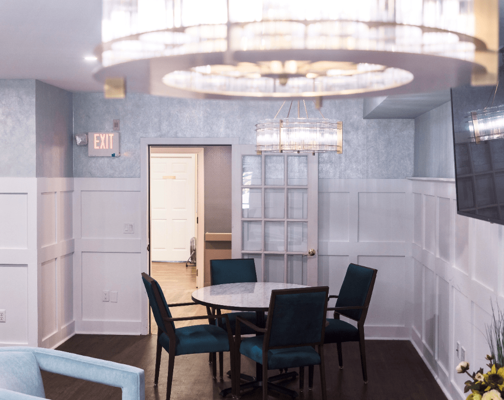 A modern dining area with stylish chandeliers and a round table surrounded by chairs.
