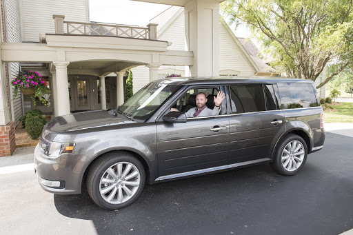 A joyful moment captured as two people enjoy a ride in their SUV.
