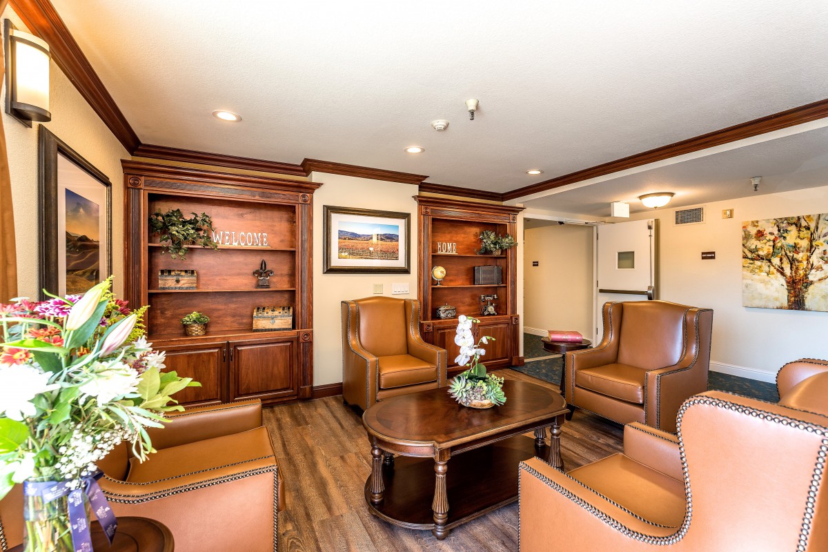 A cozy lobby with comfortable seating and elegant wooden shelves.