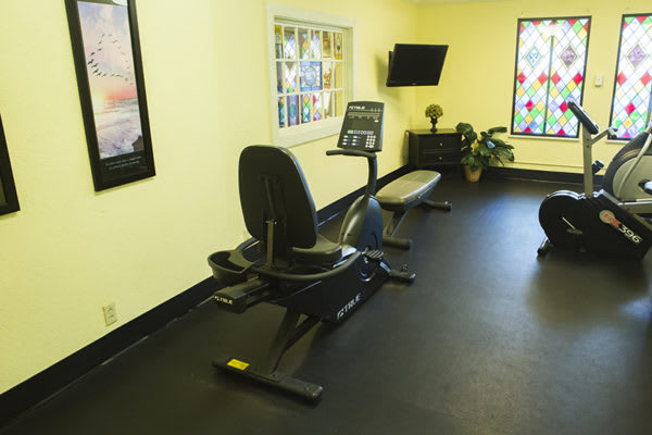 A small gym with a stationary bike and television.