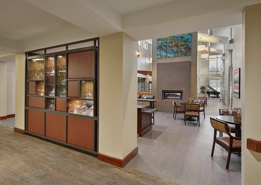 A spacious and modern hotel lobby featuring a welcoming reception area and decorative display cabinets.