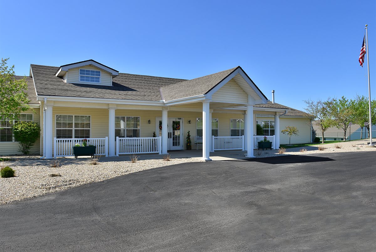 A single-story residential building with a front porch and driveway.