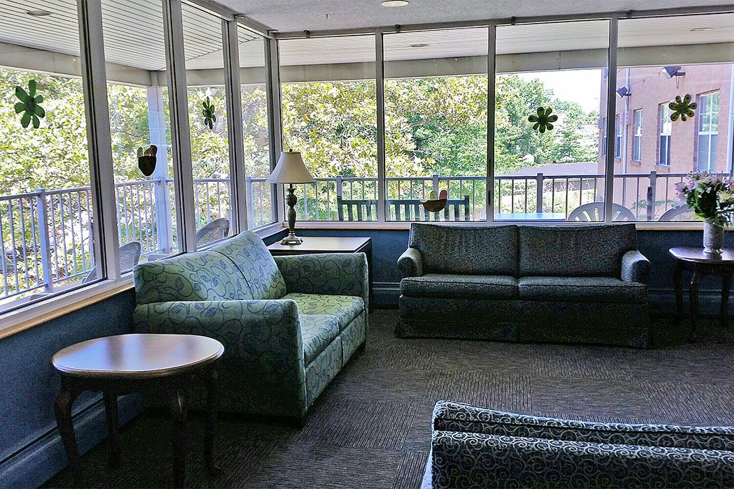 A cozy lounge area with sofas, chairs, and large windows letting in plenty of natural light.