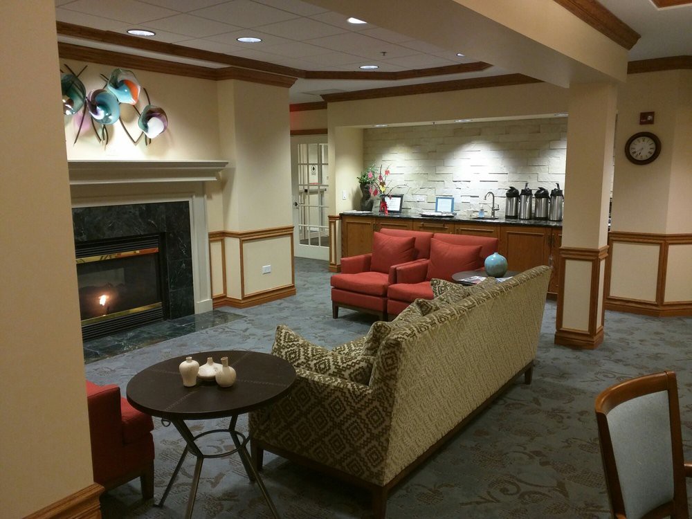 A cozy lounge area featuring a fireplace, comfortable seating, and a coffee station.