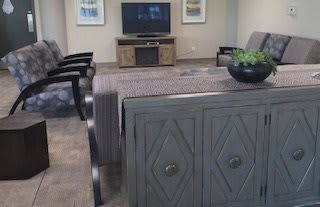 A modern living room with a TV, decorative cabinet, and seating area.