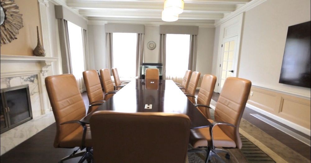 A spacious conference room with a long table and comfortable chairs.